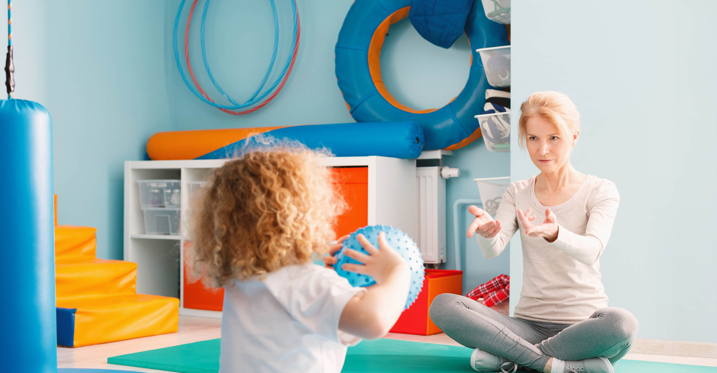 Child throwing a ball to a Physiotherapist