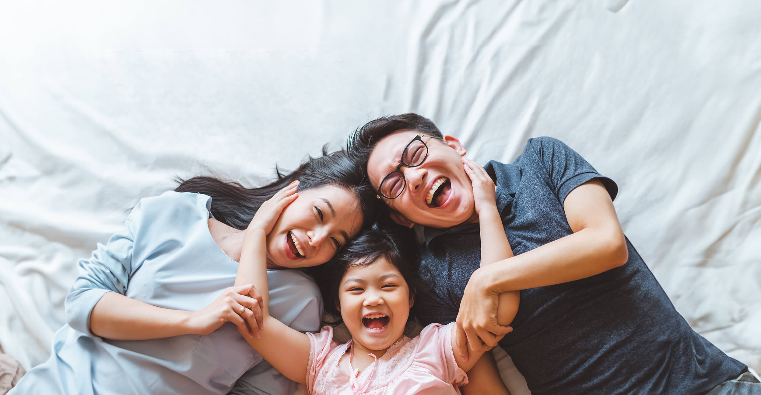 Happy family laughing on the bed