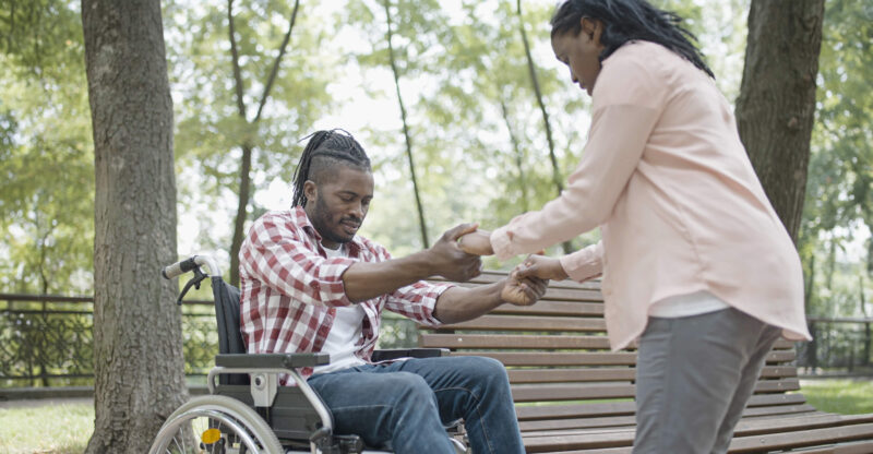 Man in wheelchair being assisted by an occupational therapist