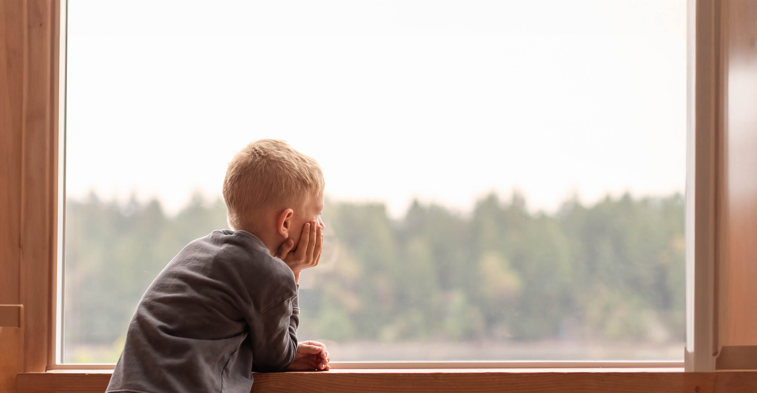 Young boy looking out the window